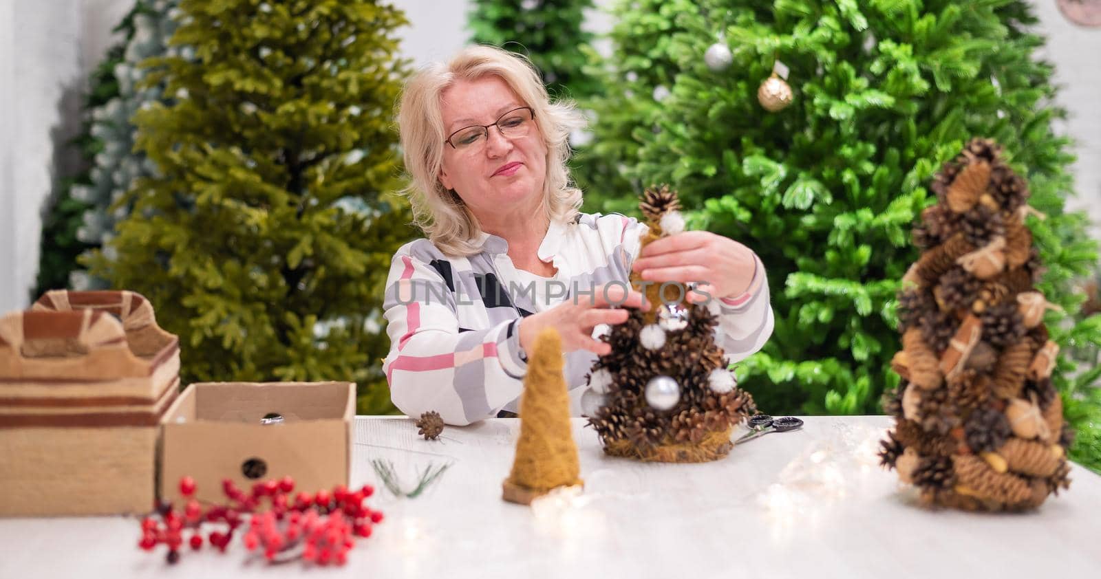 Elderly caucasian woman making cones decoration for christmas