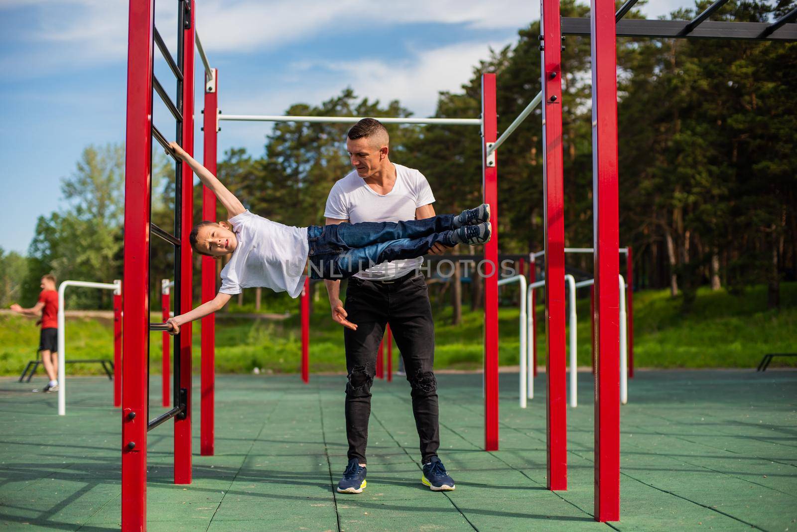 Caucasian man teaching boy to make a flag on the playground