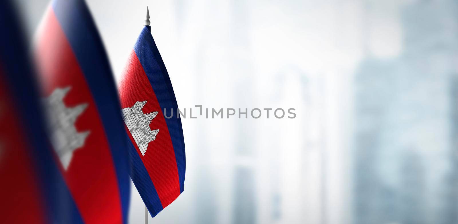 Small flags of Cambodia on a blurry background of the city.