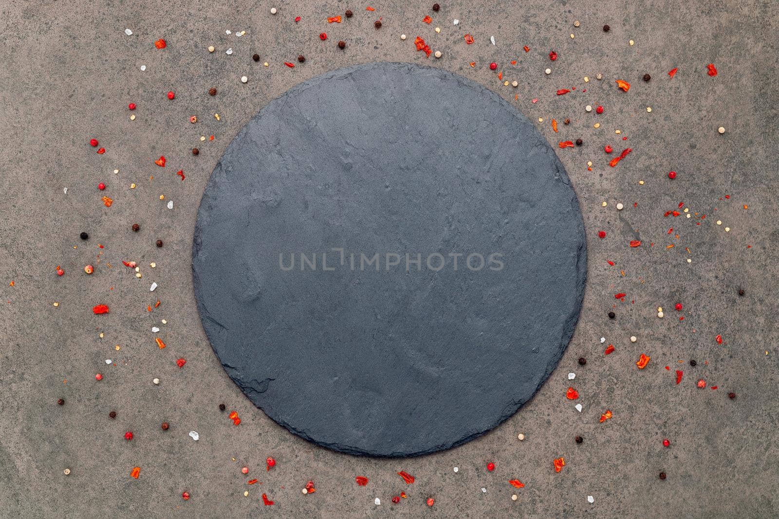 Empty pizza platte with spices set up on dark concrete background flat lay and copy space.