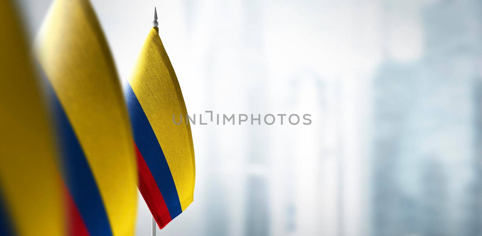 Small flags of Colombia on a blurry background of the city.