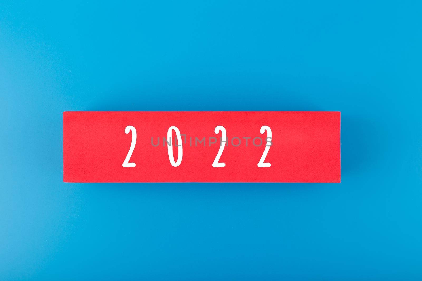 2022 numbers on red rectangle against blue background with copy space by Senorina_Irina
