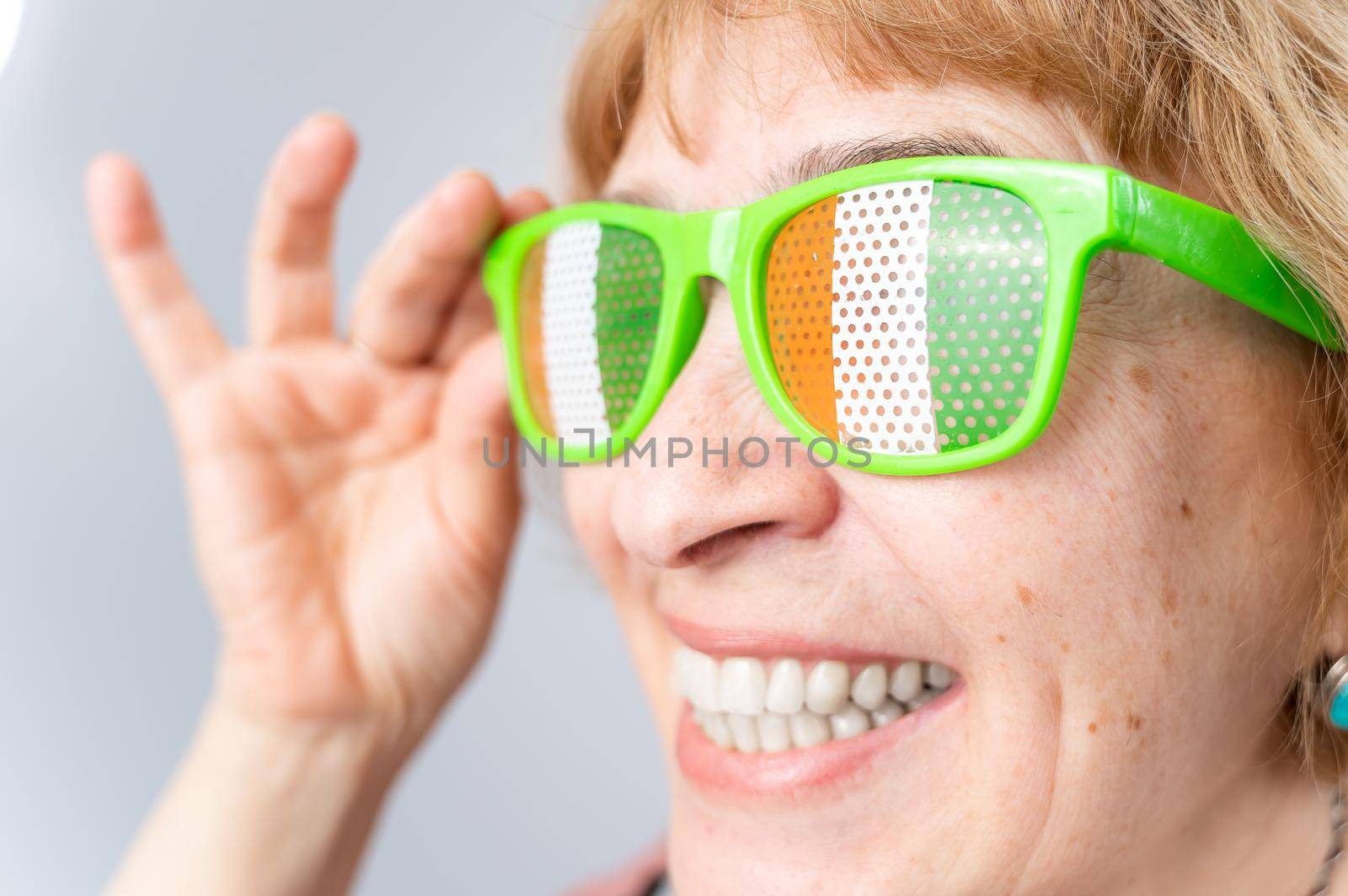 Portrait of smiling elderly woman wearing glasses with ireland flag