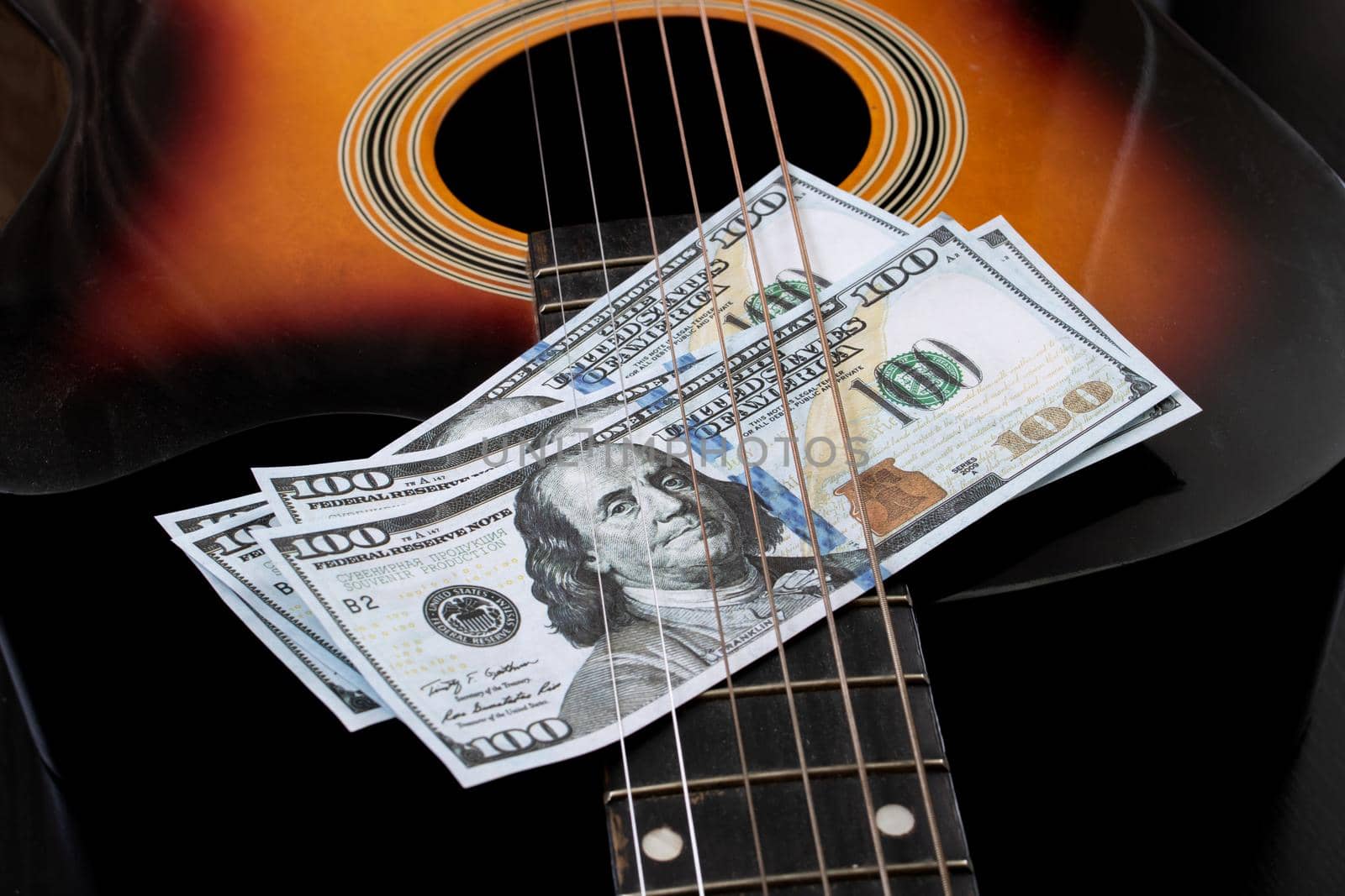 Dollar bills on an acoustic guitar close up