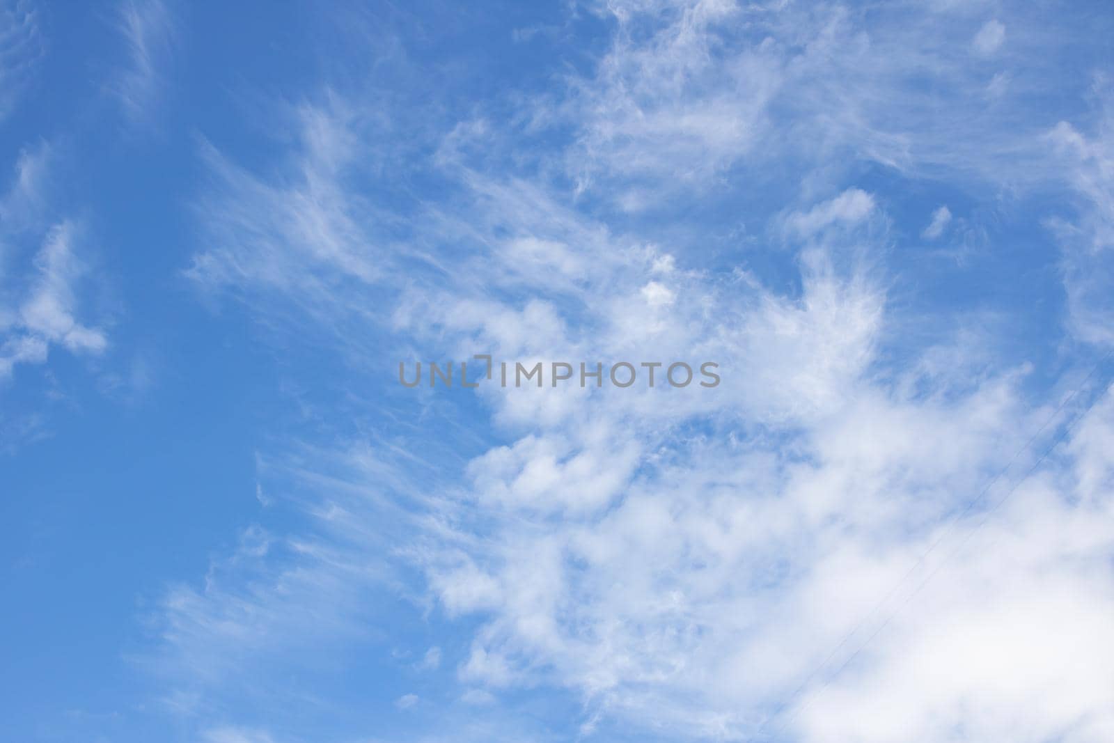 White cirrus clouds in the blue sky close up