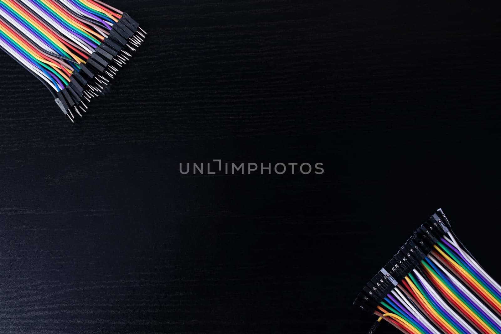 Multicolored computer wires on a wooden table copy space