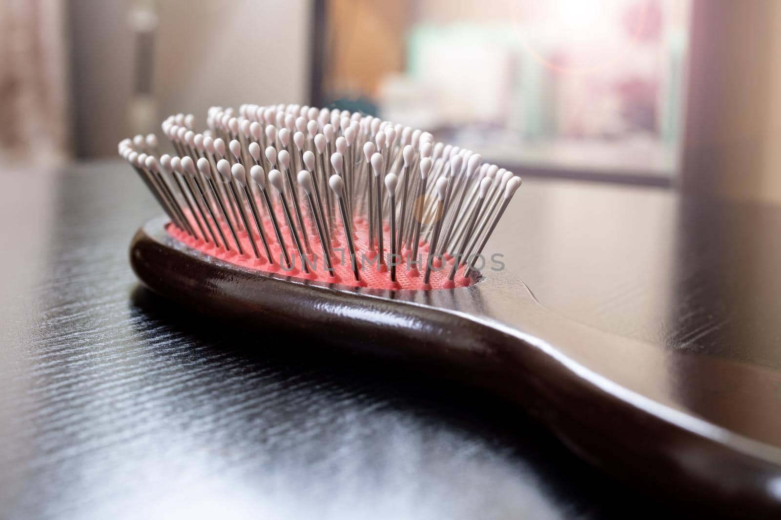 Wooden hairbrush on a wooden table close up