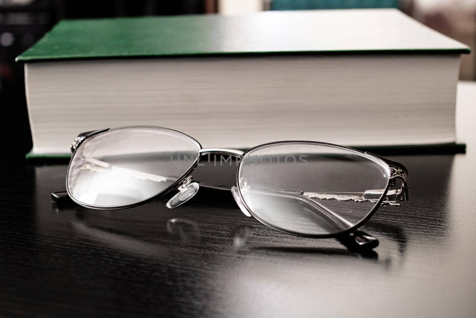 Glasses and green book on a wooden table