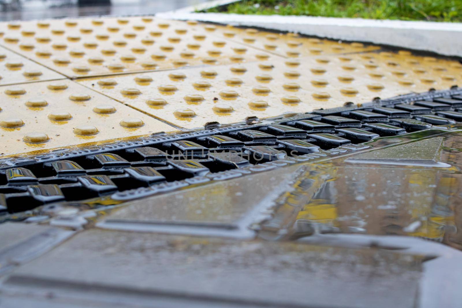 Rain grate on the sidewalk in the rain close up