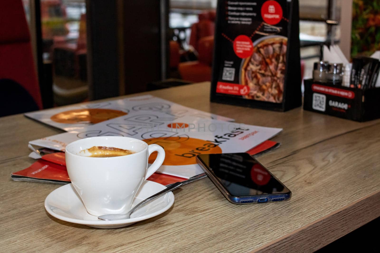 BELARUS, VITEBSK - SEPTEMBER 10, 2020: Cup of coffee and magazines on the table by Vera1703