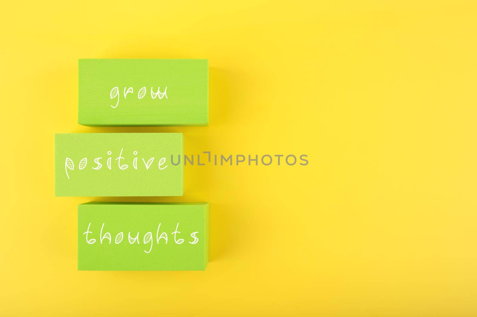Positive affirmation, mental health or quote concept. Grow positive thoughts written on green rectangles on yellow background with copy space. Motivational text for inner piece