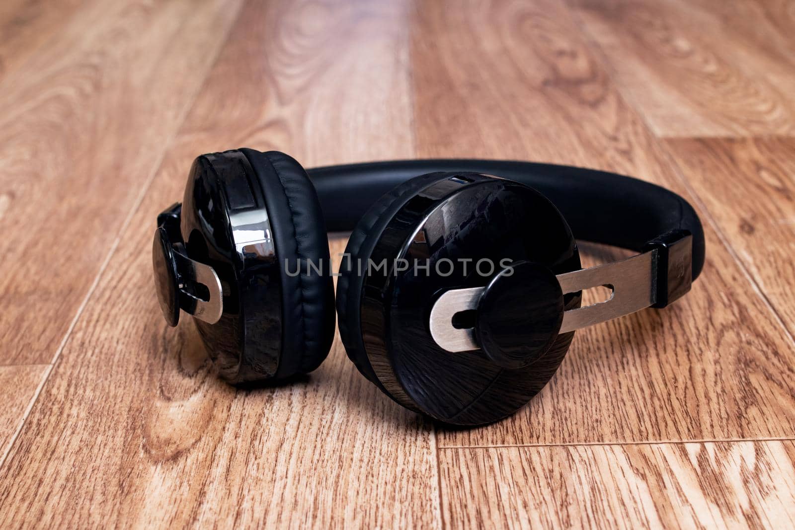 Black headphones on a wooden table close up