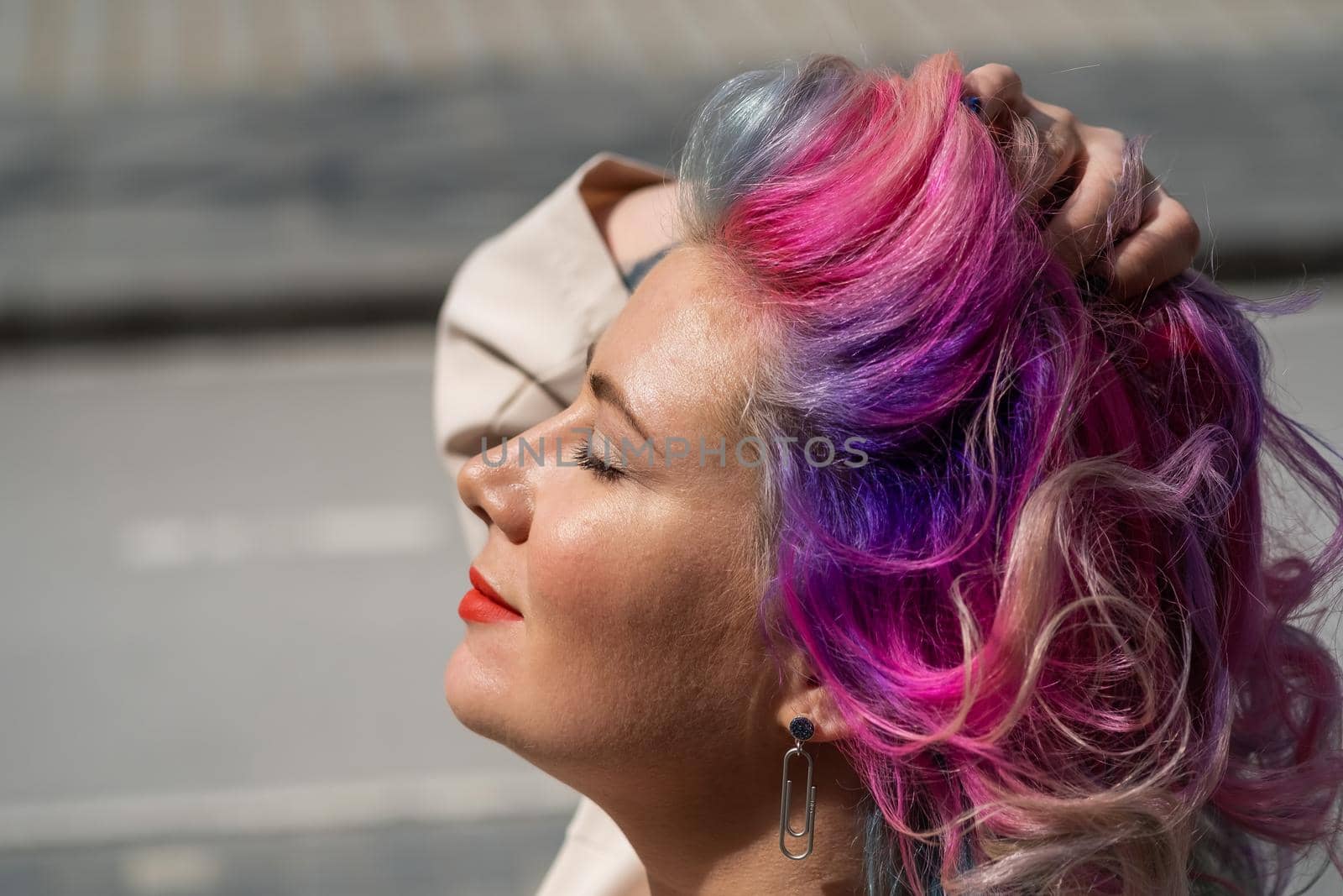 Close-up portrait of curly Caucasian woman with multi-colored hair. Model for hairstyles.