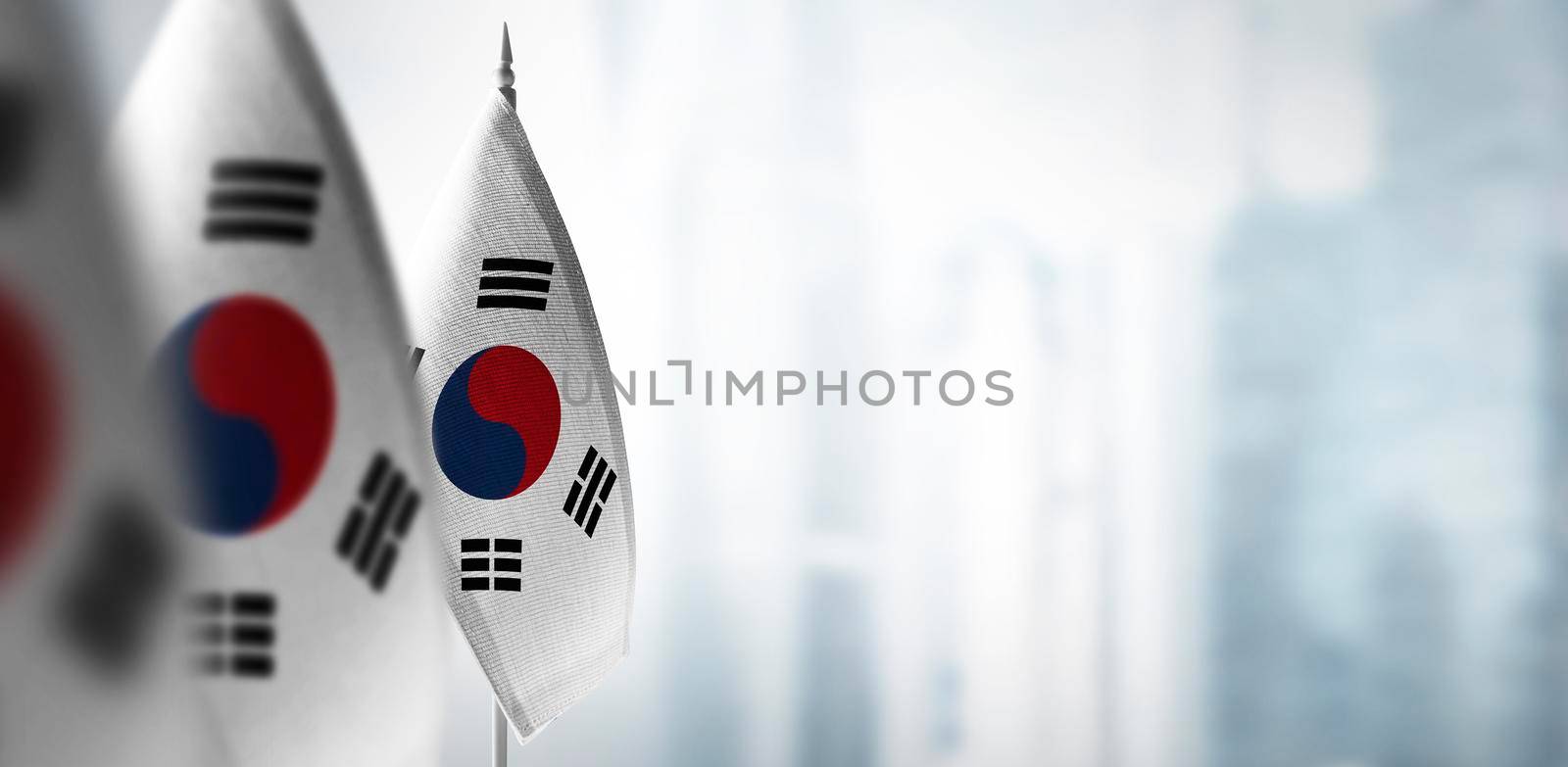 Small flags of South Korean on a blurry background of the city by butenkow