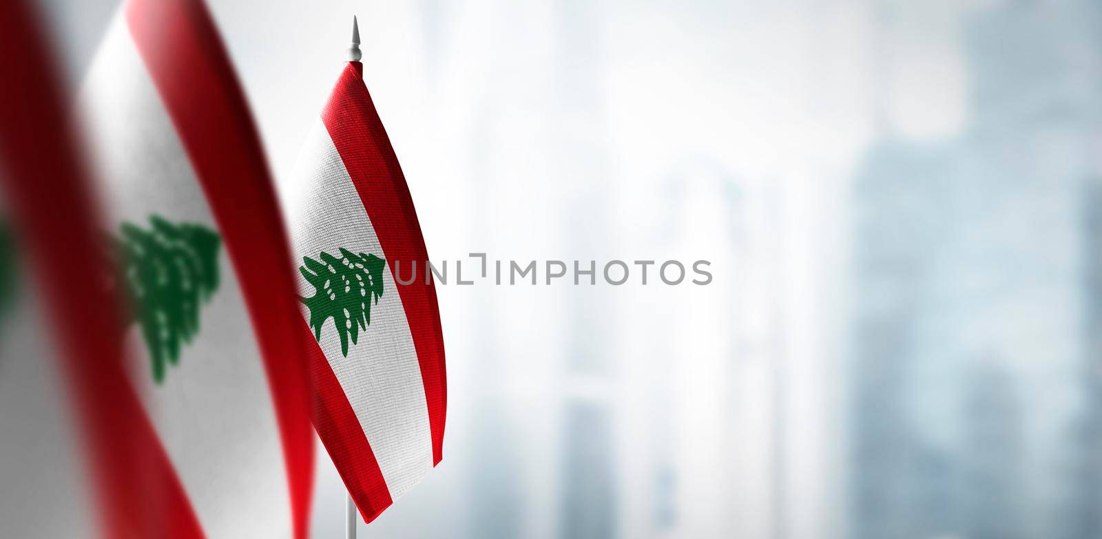 Small flags of Lebanon on a blurry background of the city.