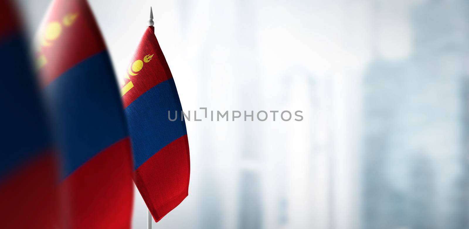 Small flags of Mongolia on a blurry background of the city.
