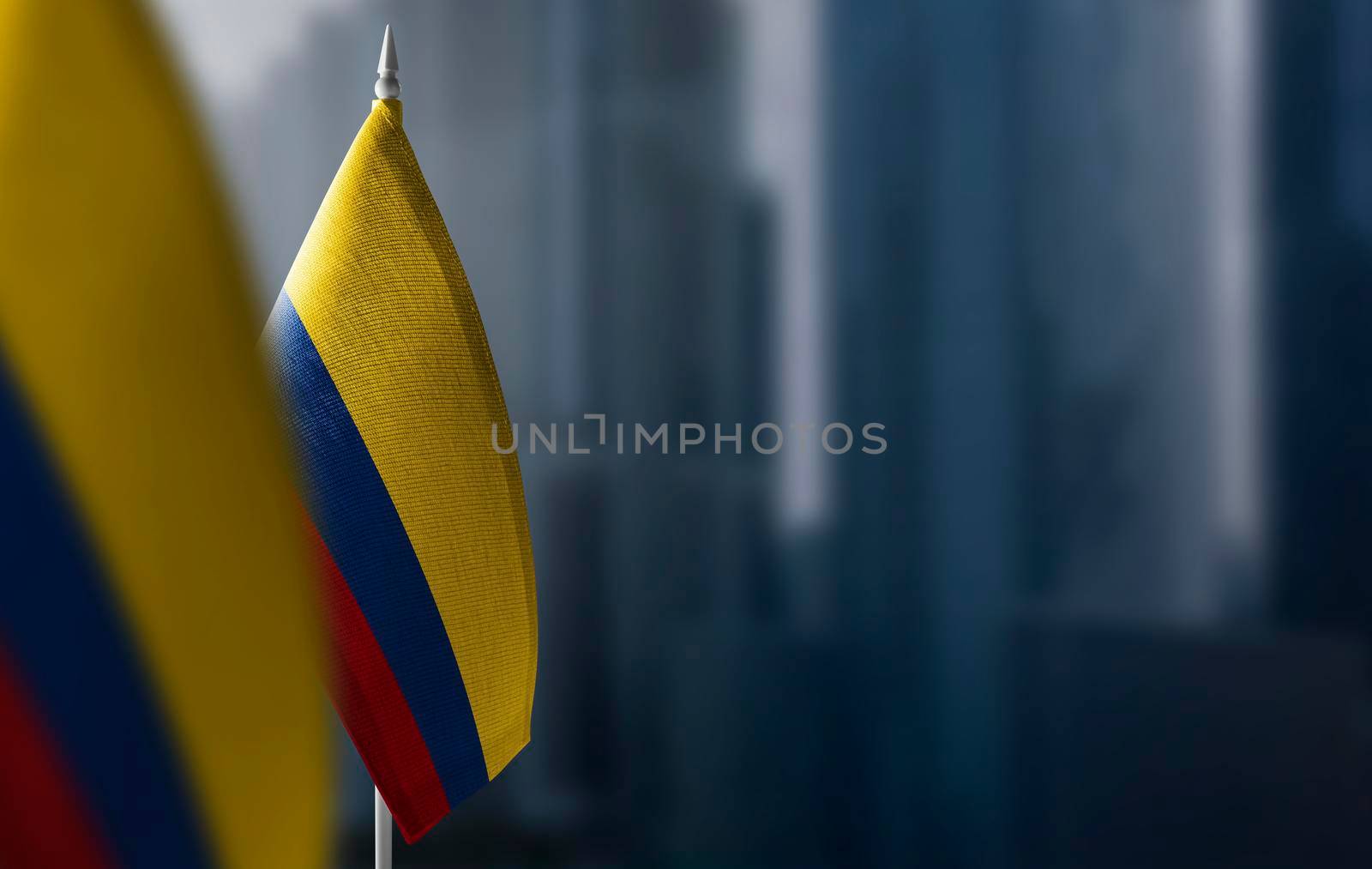 Small flags of Colombia on a blurry background of the city.