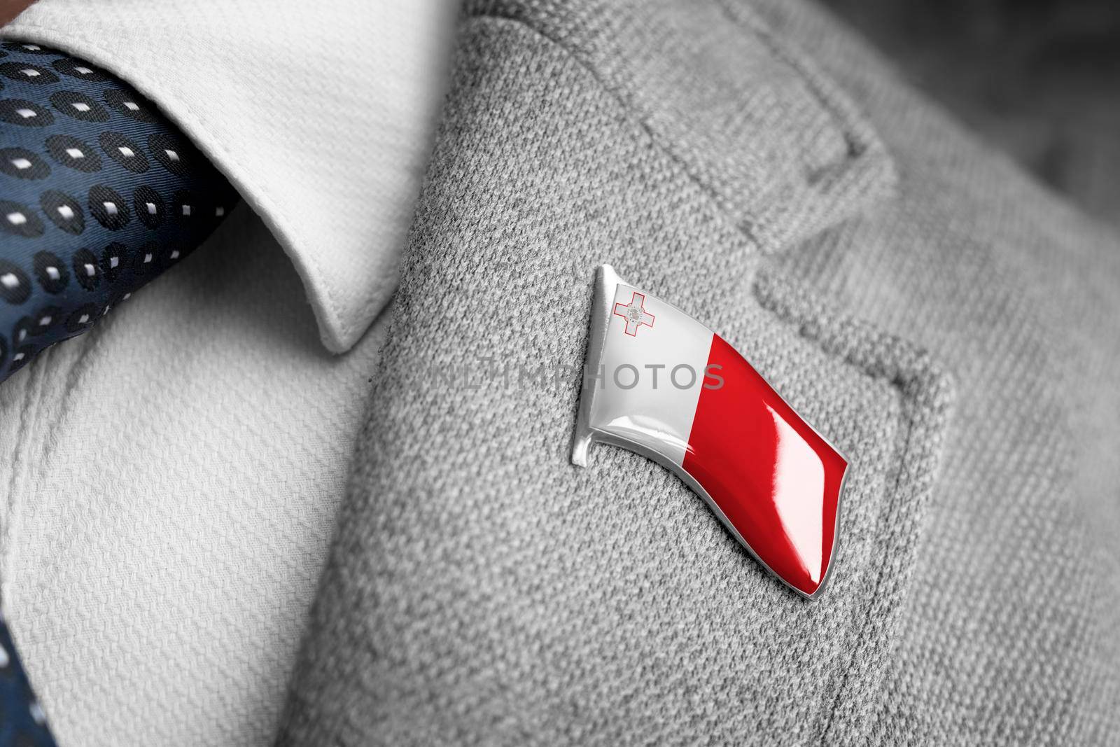 Metal badge with the flag of Malta on a suit lapel.