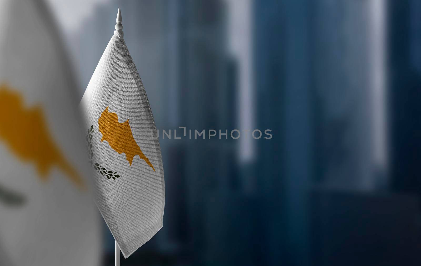 Small flags of Cyprus on a blurry background of the city.