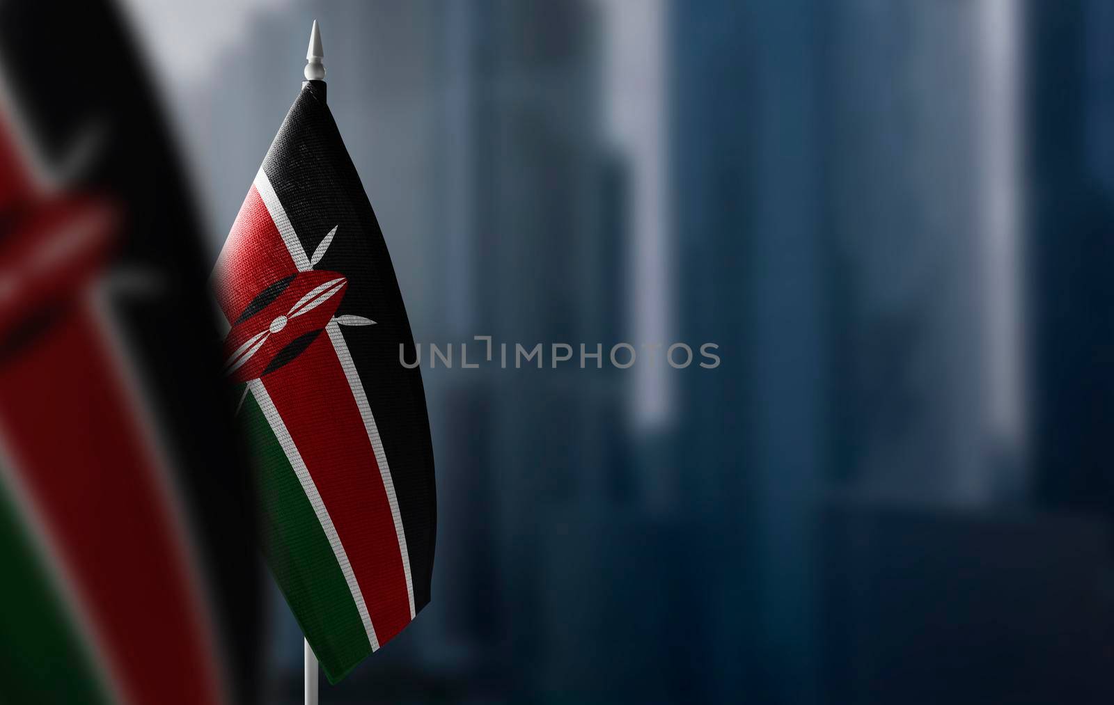 Small flags of Kenya on a blurry background of the city.