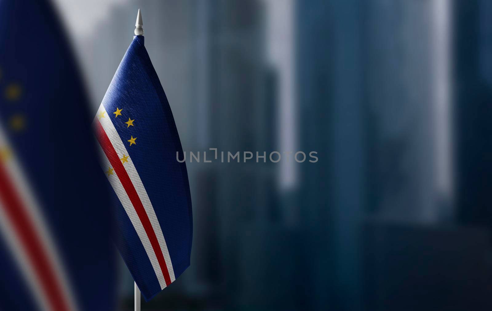Small flags of Cape Verde on a blurry background of the city.