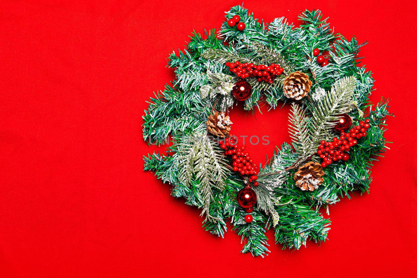 Christmas wreath on a red background. New Year and Christmas. Festive decor. Copy spice