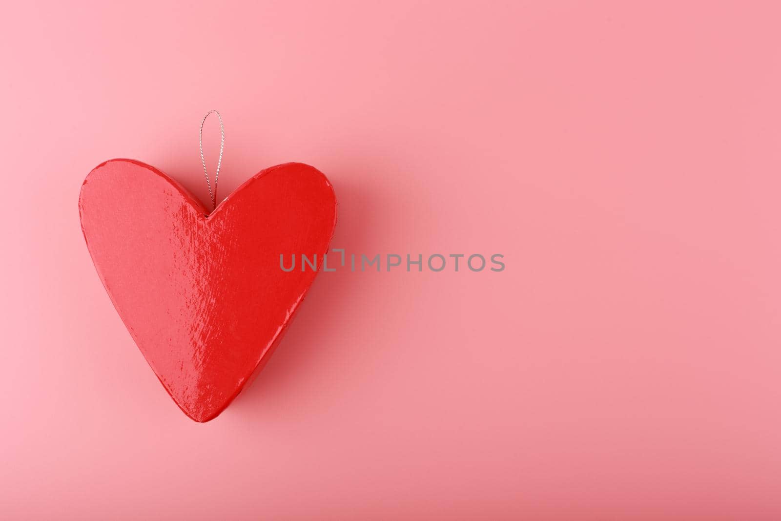 Red heart shaped gift box on bright pink background with copy space. Concept of St. Valentine's day, love and couple's gifts for holidays and anniversary. 