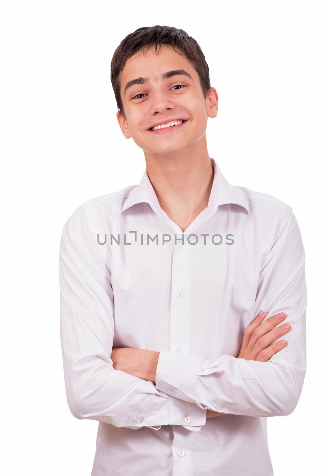 Portrait of happy smiling young man wearing a white shirt standing with hands folded against isolated on white