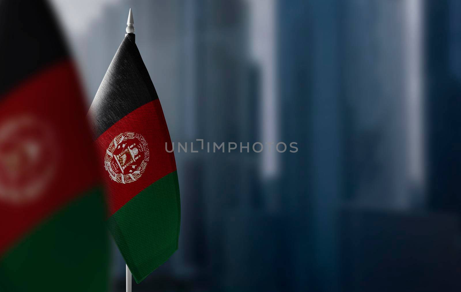 Small flags of Afghanistan on a blurry background of the city.