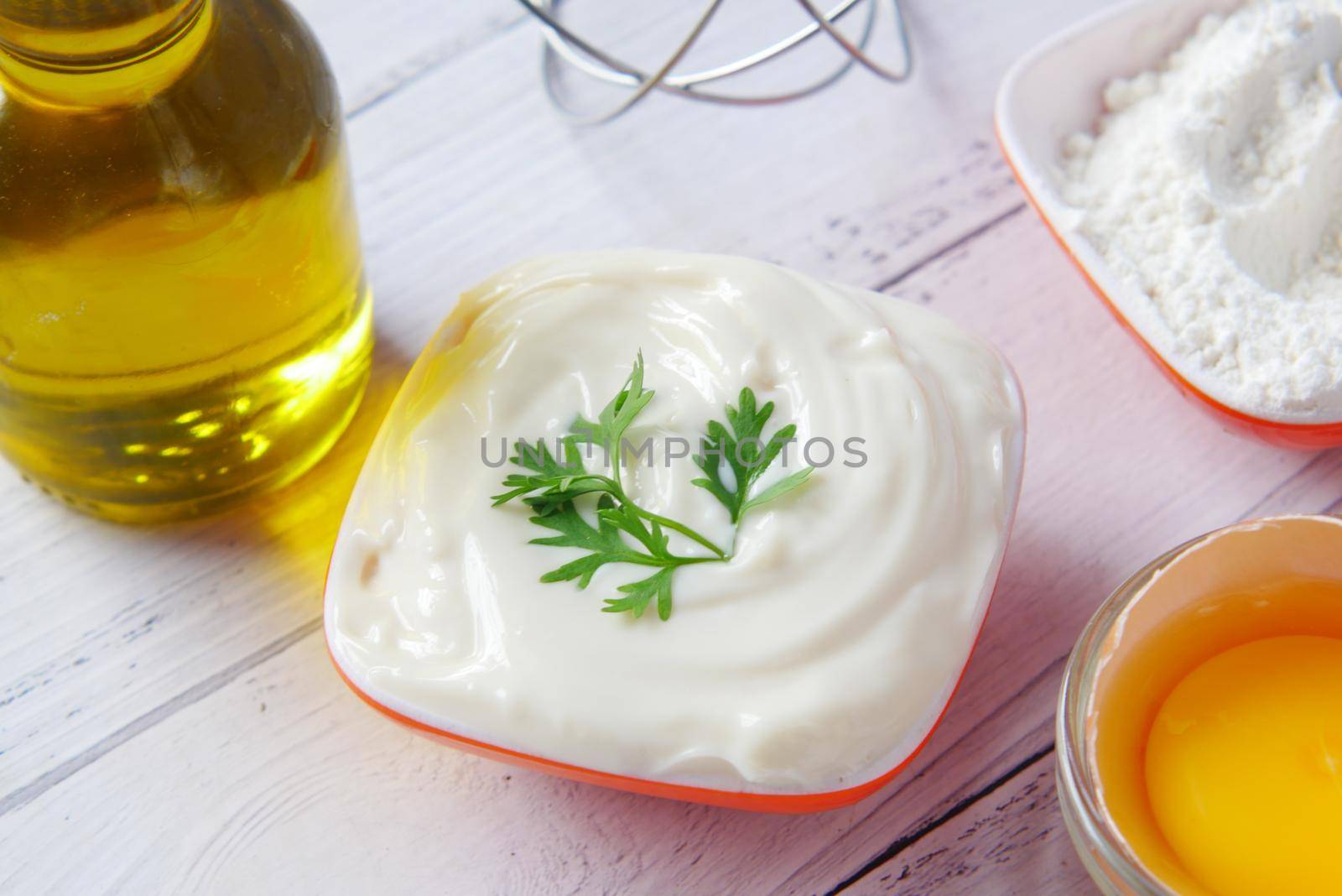 Mayonnaise in container , oil and eggs on table ,