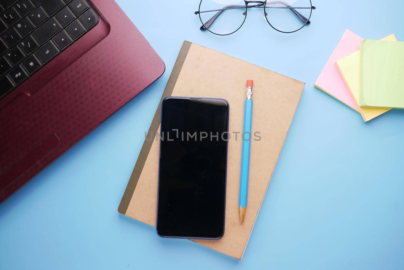 top view of smart phone and notepad on table .