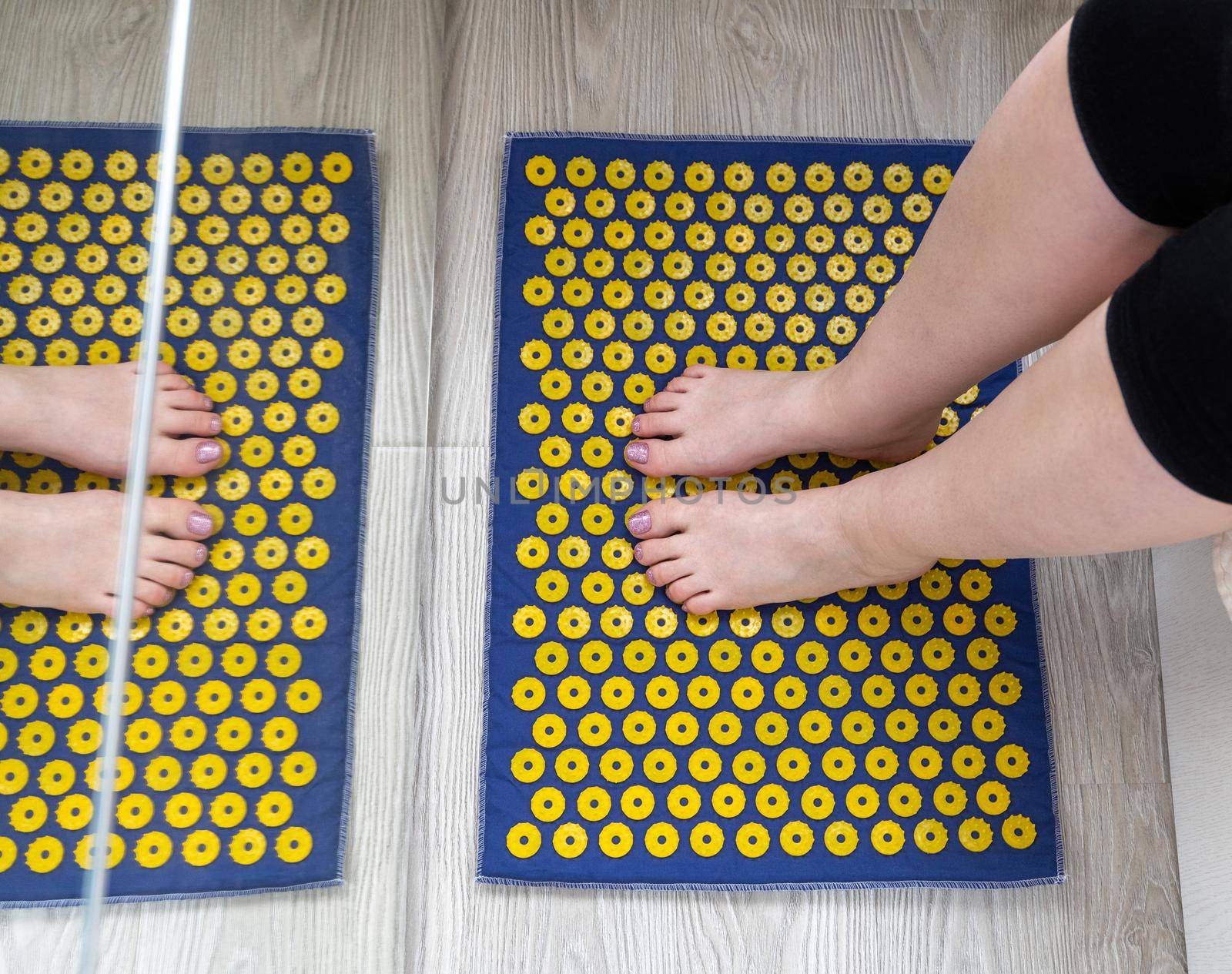 Women's feet stand on a needle mat - foot massage using an applicator Kuznetsov, Russia by olgavolodina