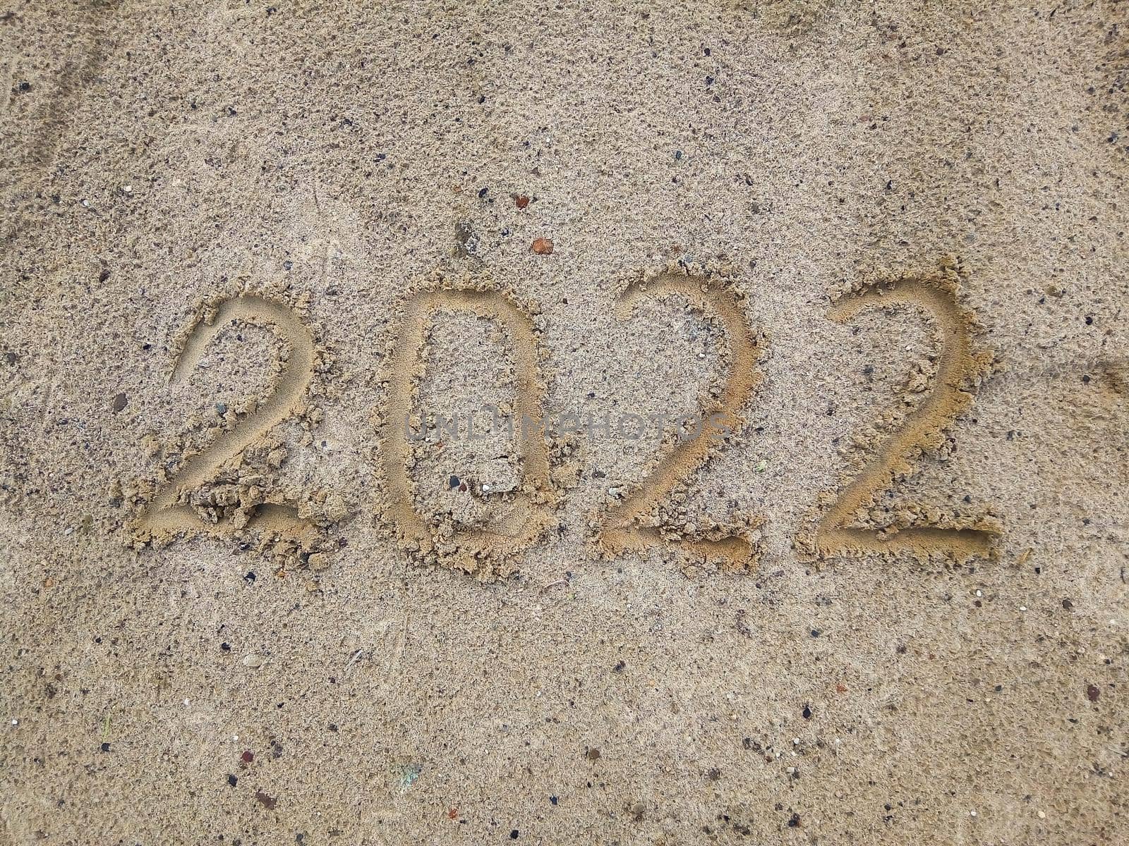 Happy New Year 2022. The symbol of the number 2022 on the sand is a New Year Greeting Card. Copy space by lapushka62