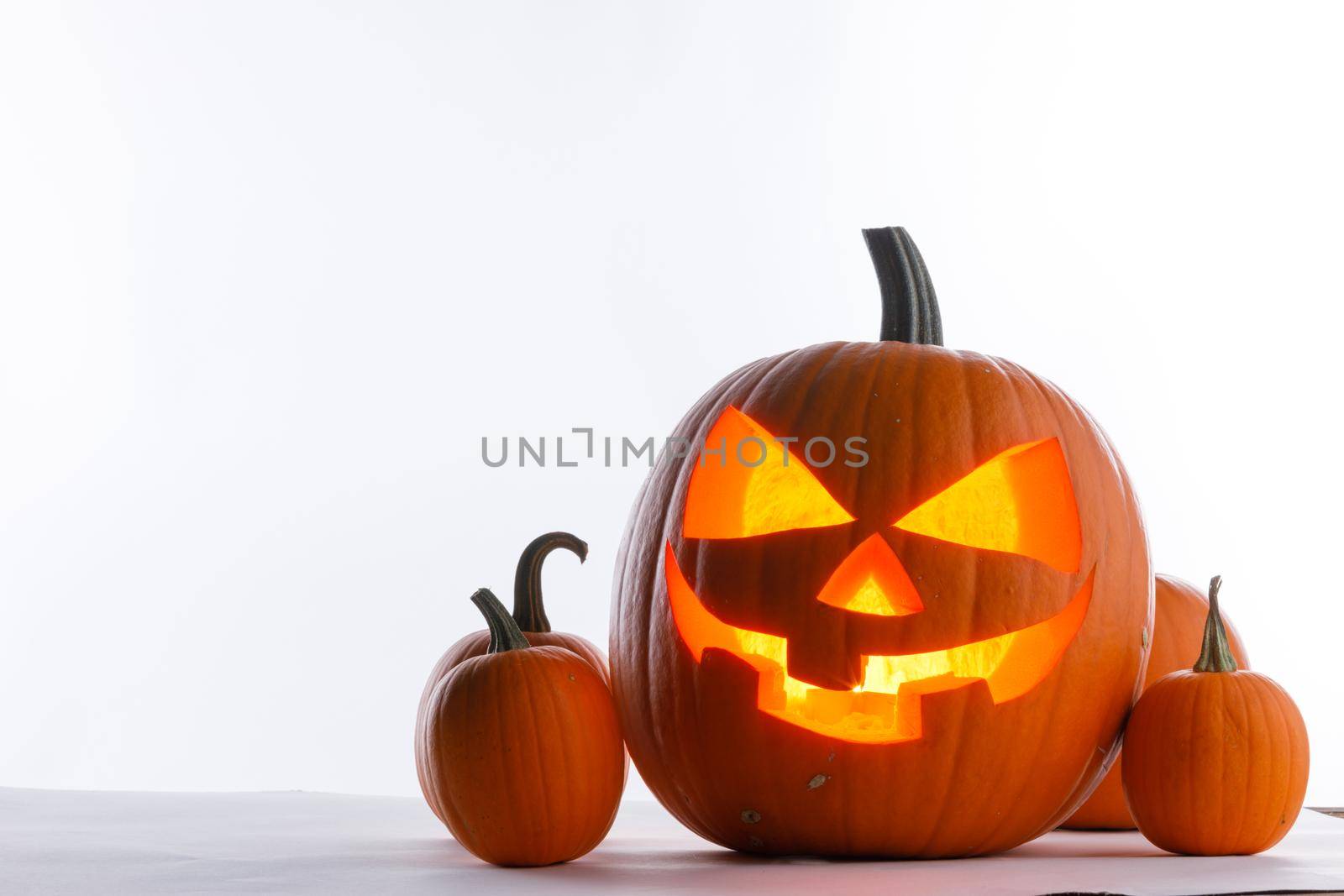 Halloween pumpkin with cut face and candle inside isolated on white background