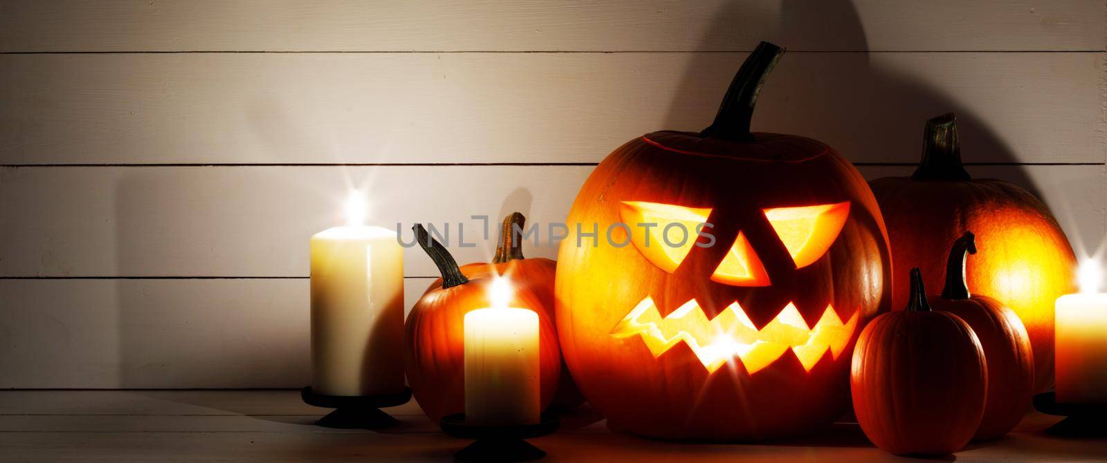 Halloween pumpkins with cut faces and candles dark holiday card