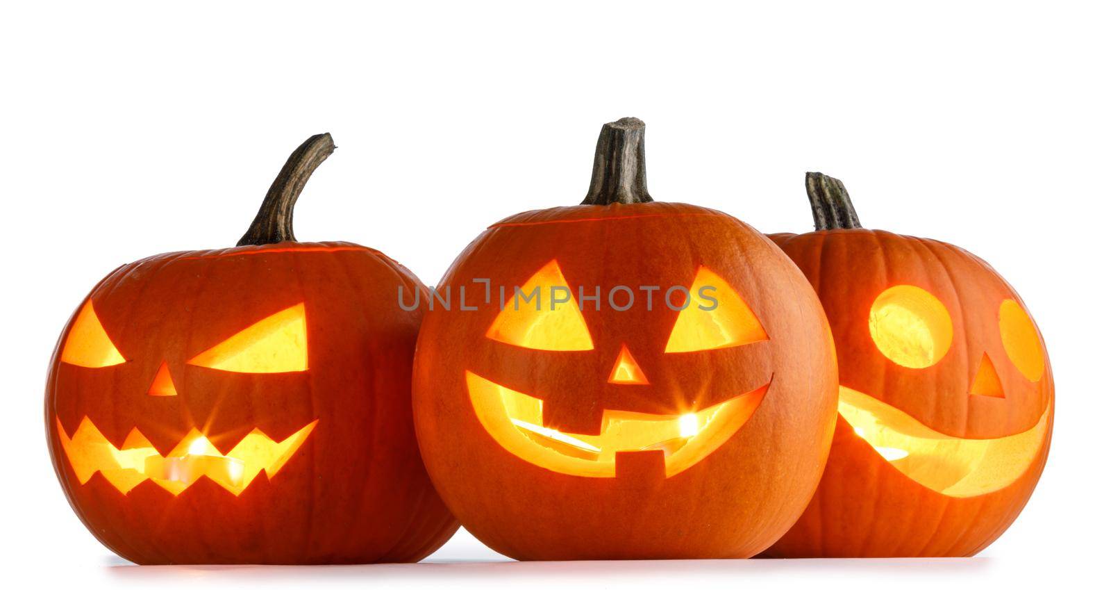 Three glowing Halloween Pumpkin lanterns isolated on white background