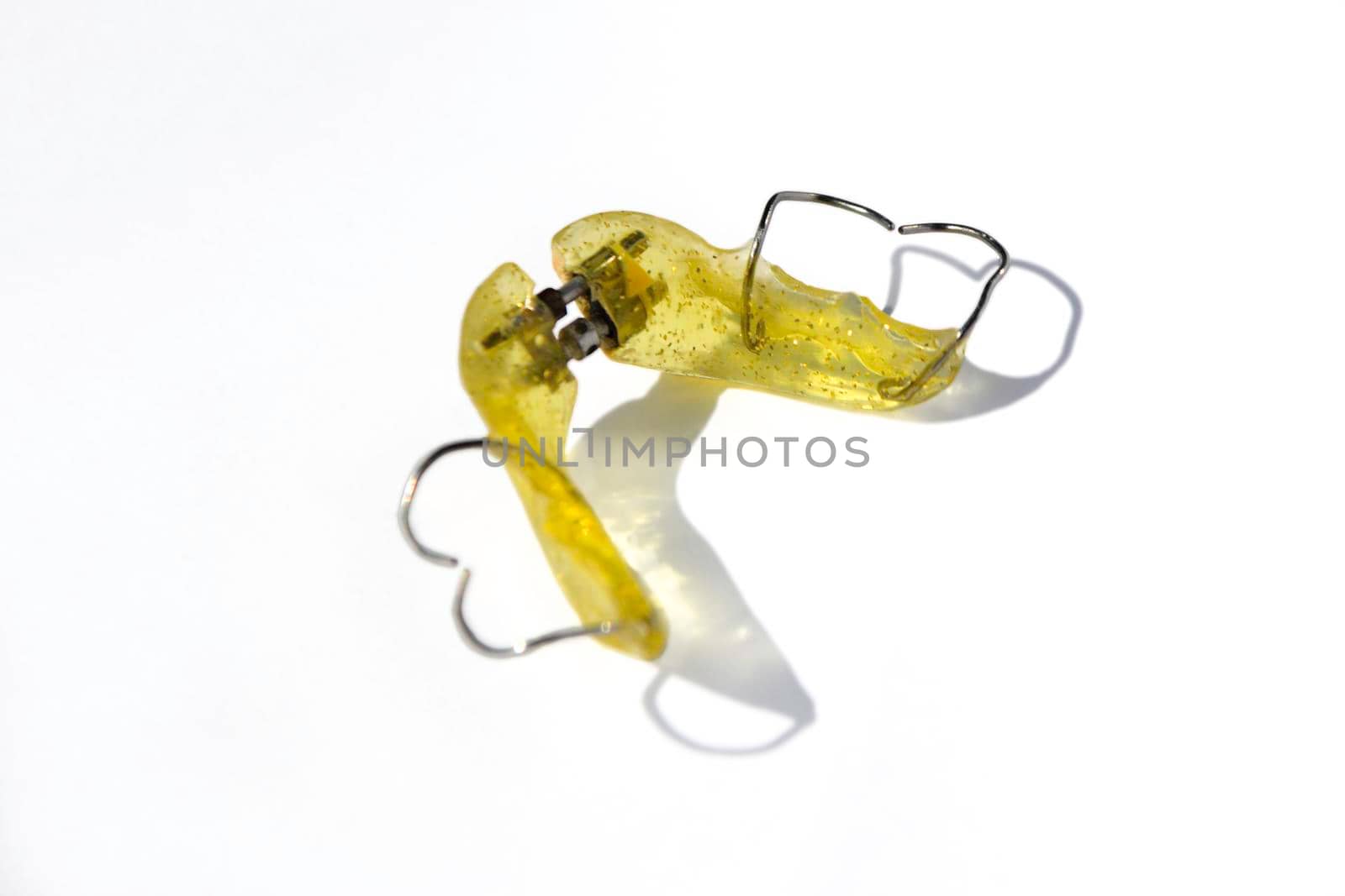 Close up of pink removable dental plate maxilla retainer isolated on background by milastokerpro