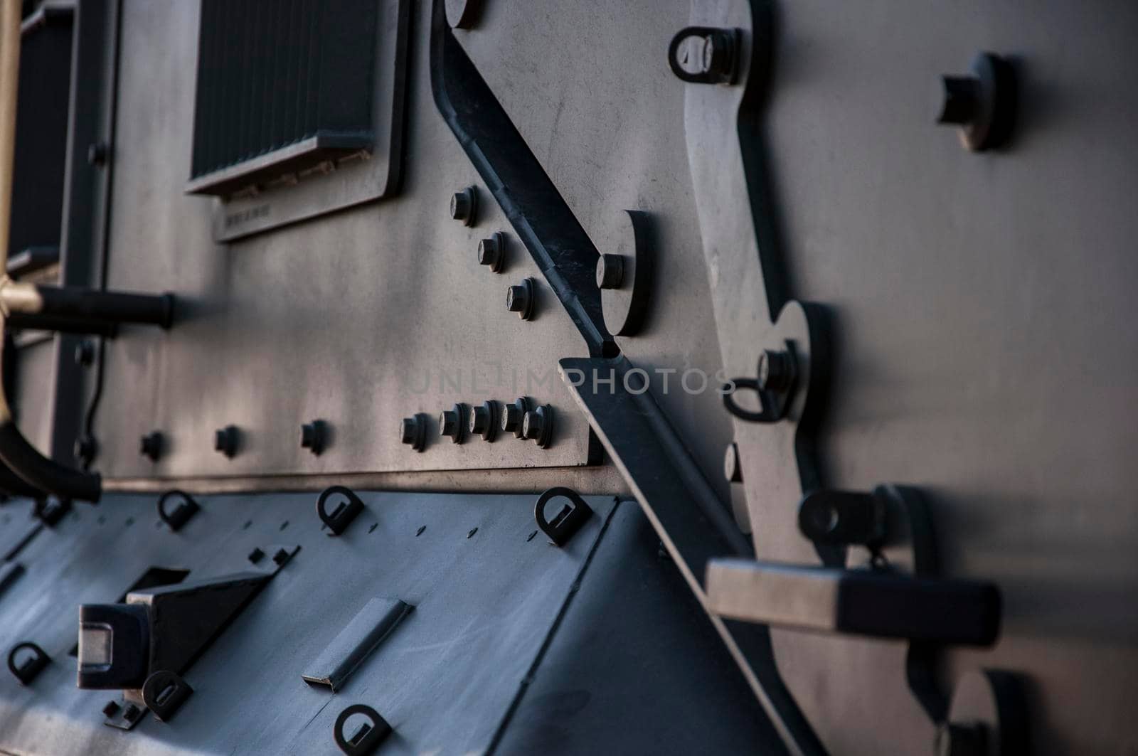 Details artillery gun. Camouflage surface with exfoliated paint and rivets on the armor. Military equipment background. Close-up
