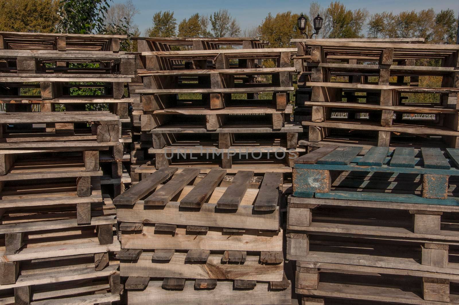 stacks of wooden pallets in a warehouse yard by inxti