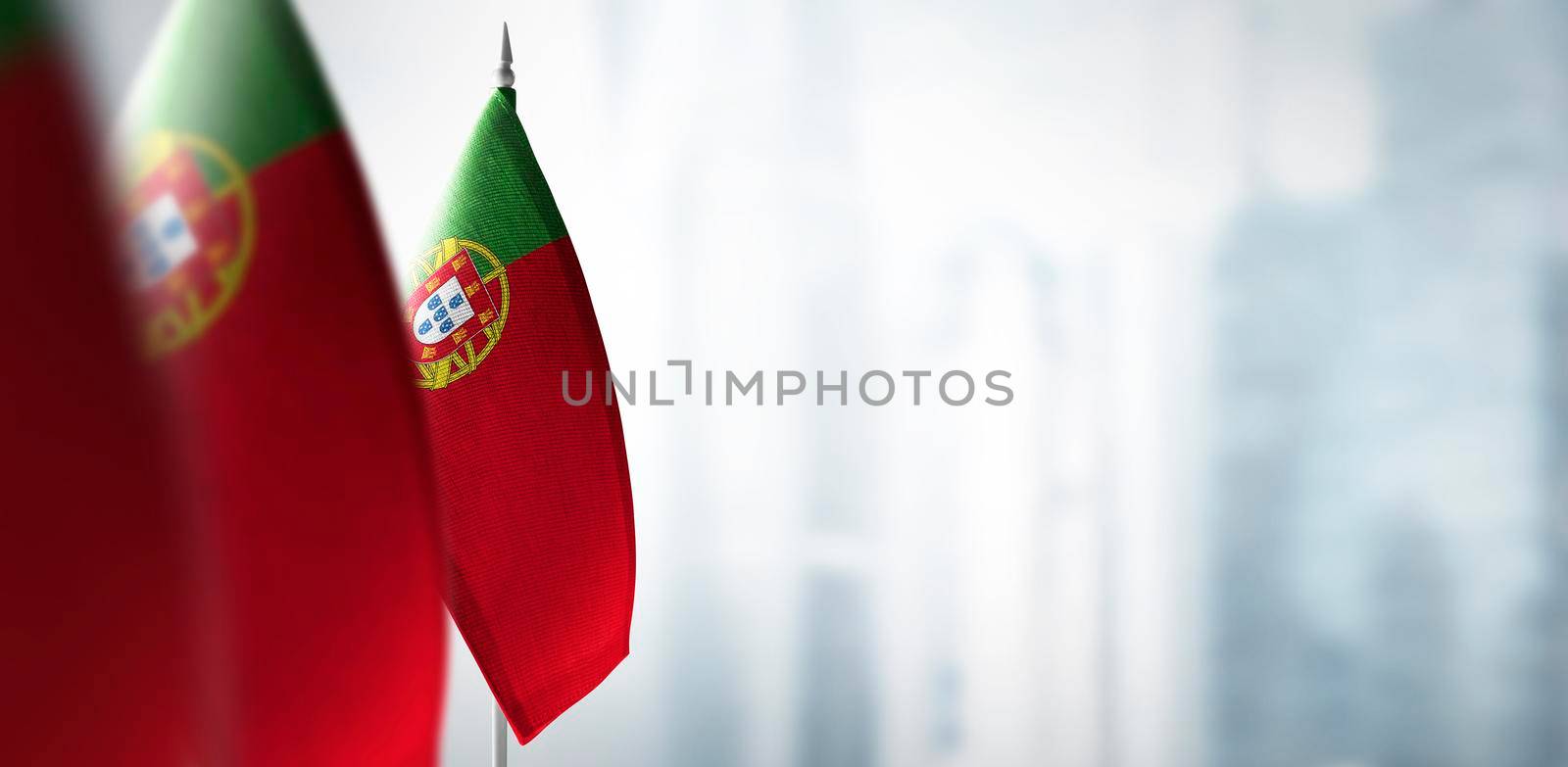 Small flags of Portugal on a blurry background of the city.