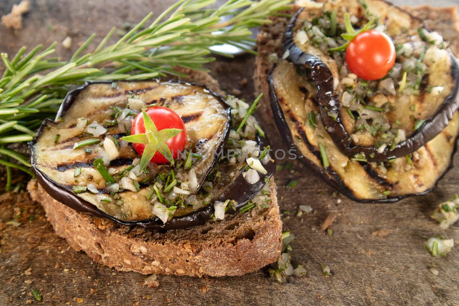 Wholemeal bread bruschetta with grilled aubergines Pachino tomatoes flavored with rosemary and garlic 