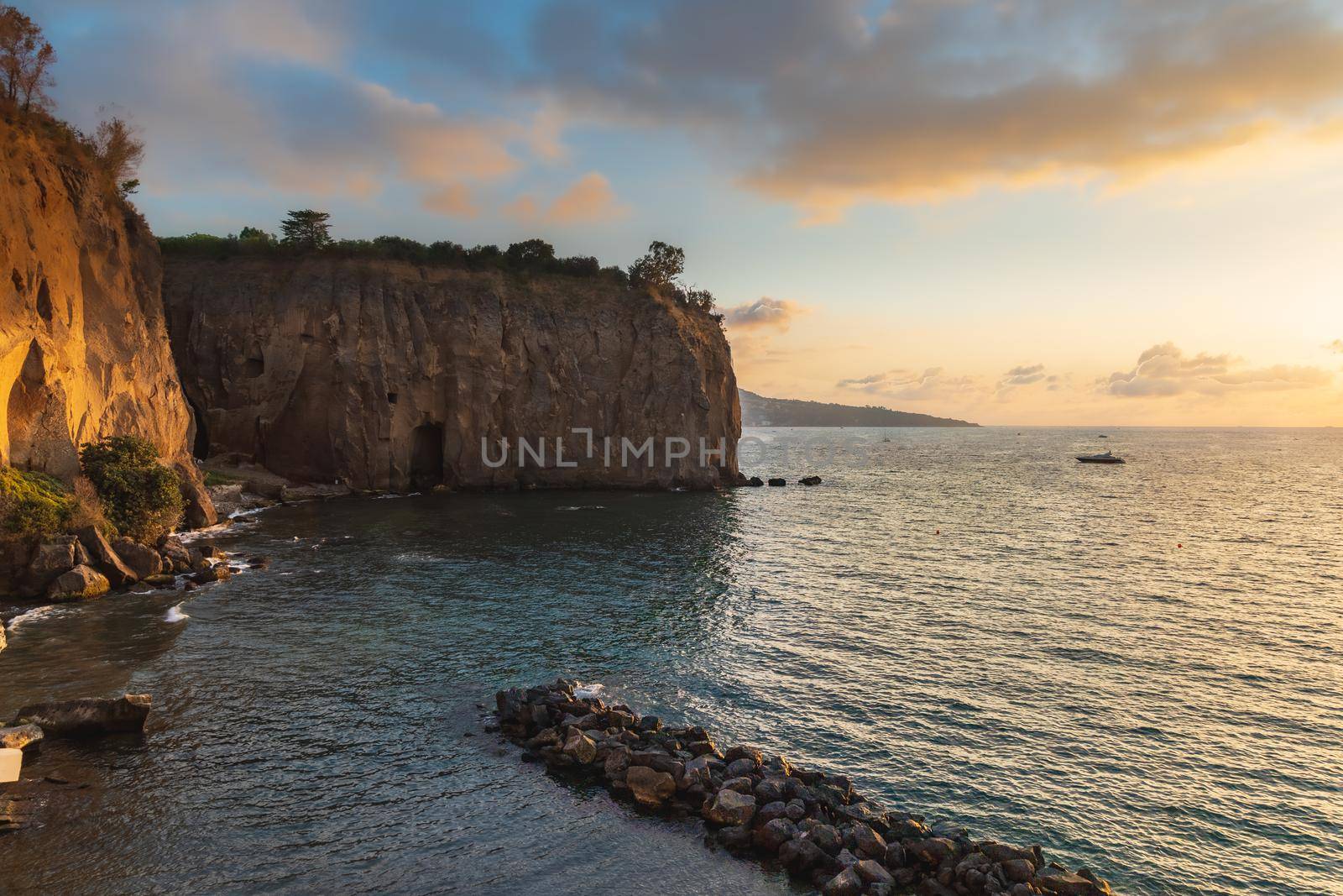 Beautiful sunset over the sea next to shore and high cliffs by Wierzchu