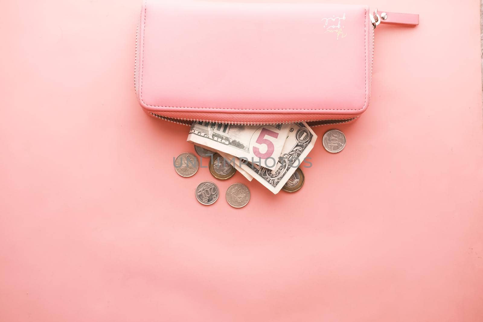 us dollar cash in leather on pink background .