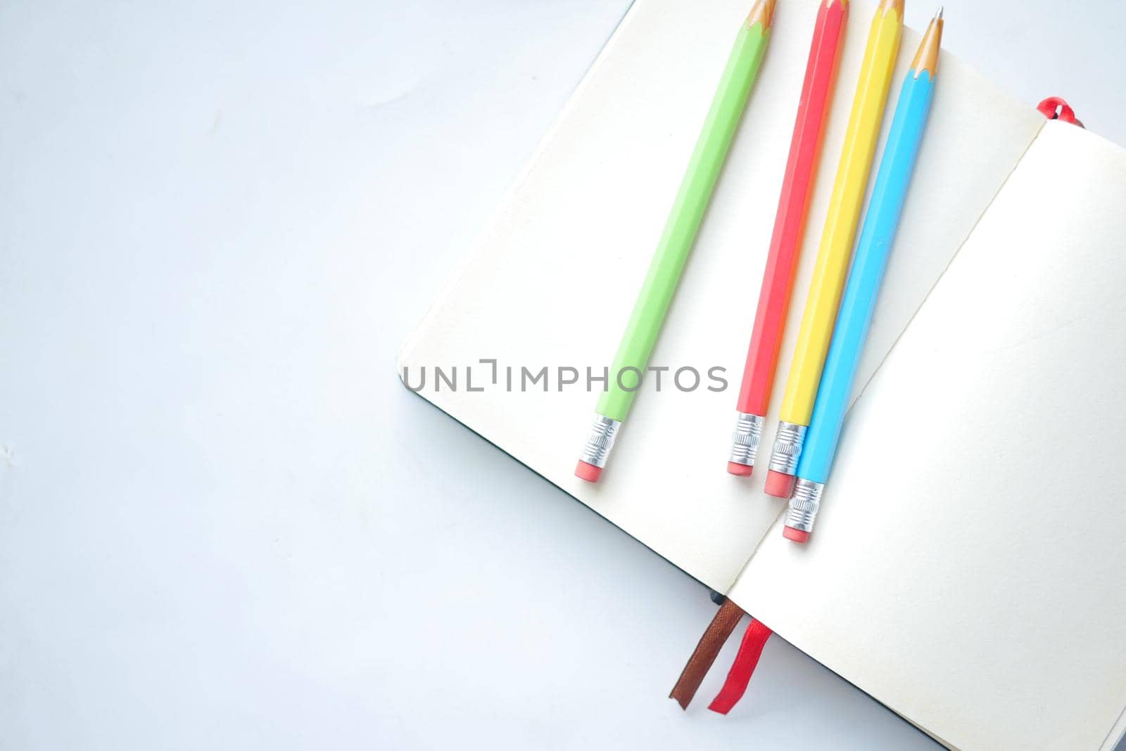 Close up of colorful pencils on notepad .