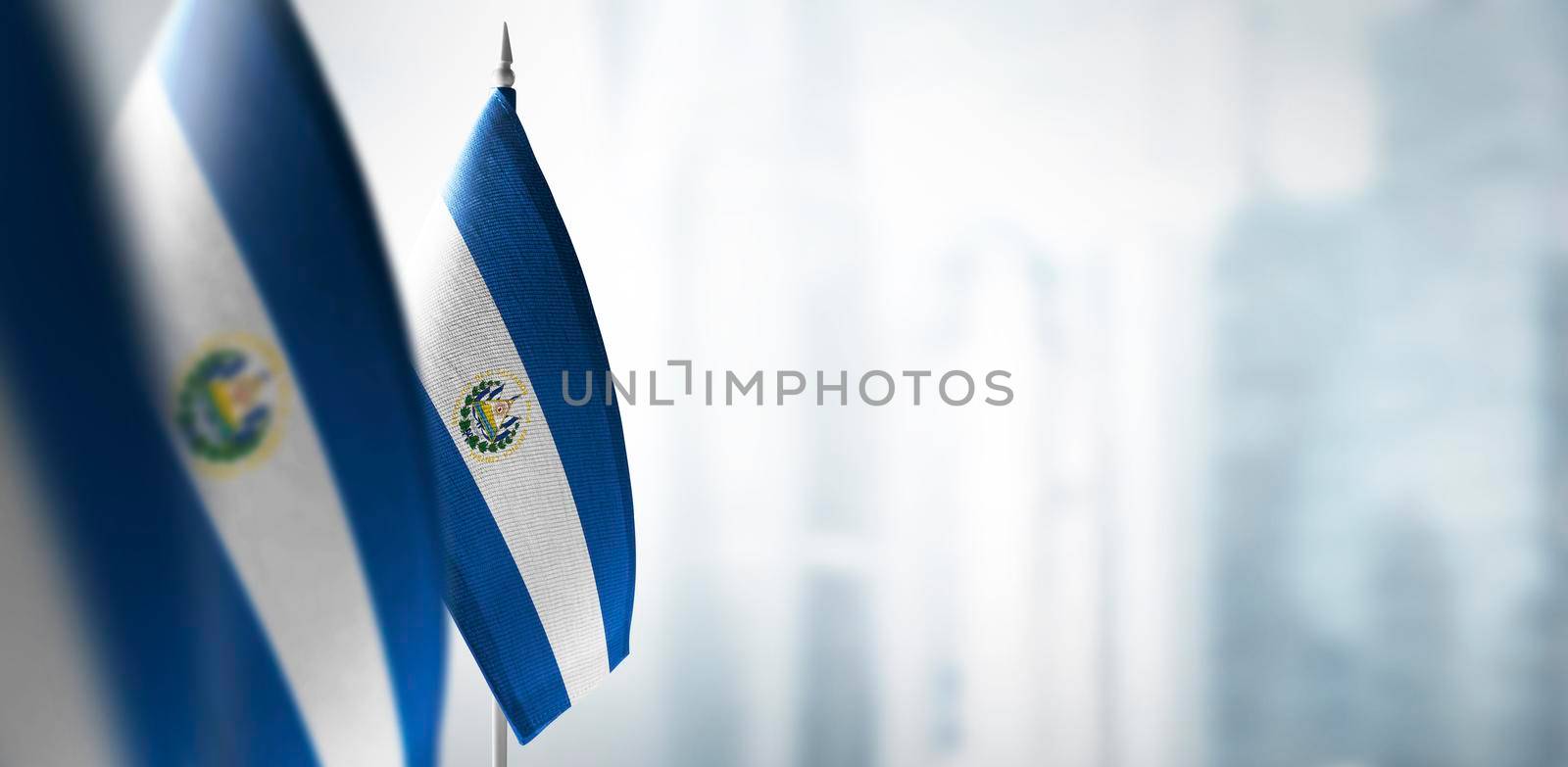 Small flags of Salvador on a blurry background of the city by butenkow