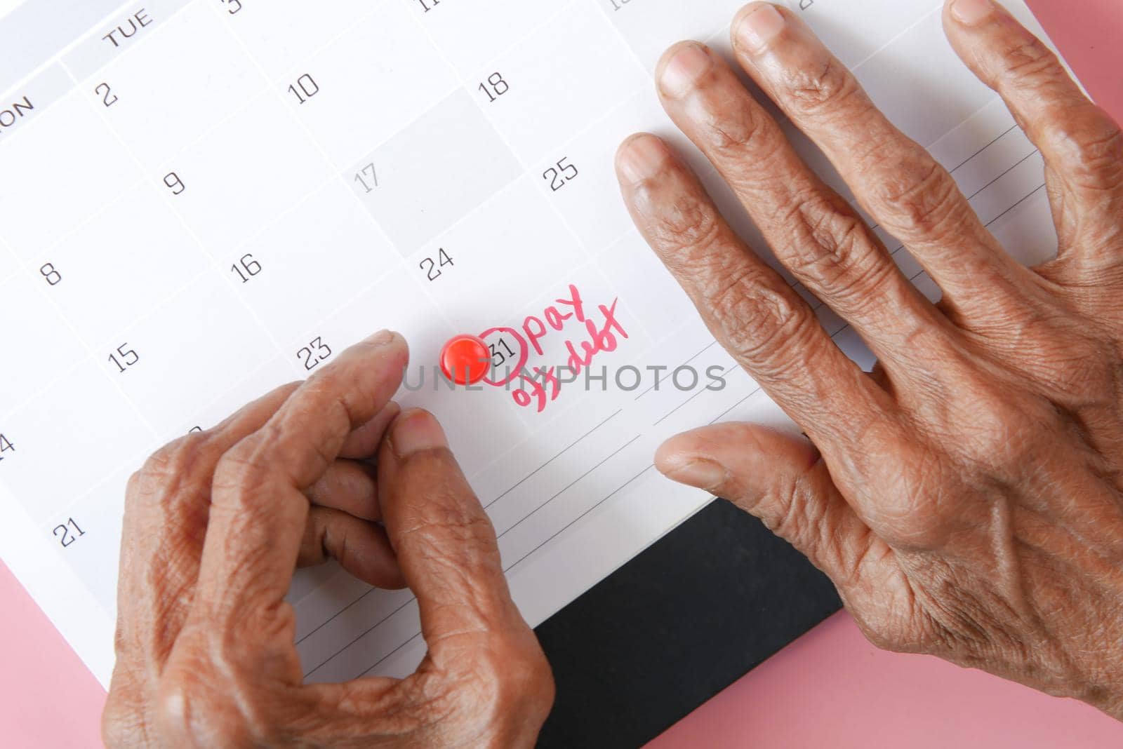 senior women hand on calendar pointing pay off debt text by towfiq007