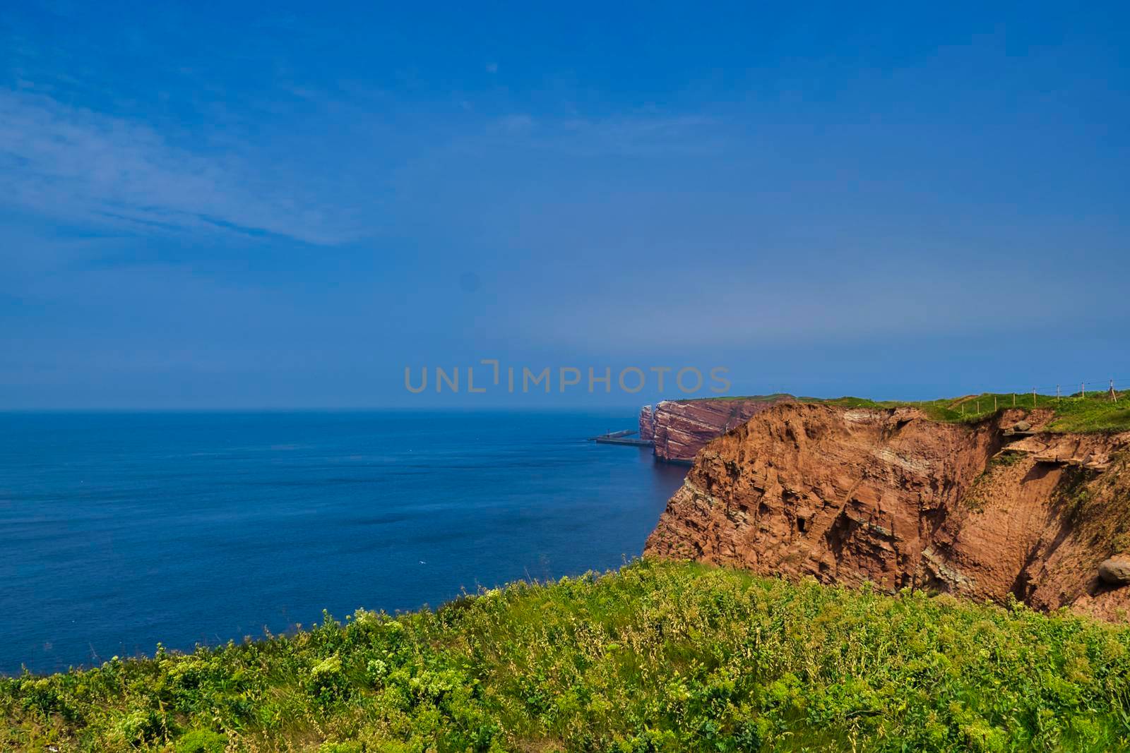 view to the Heligoland Coastline with red rocks by Bullysoft