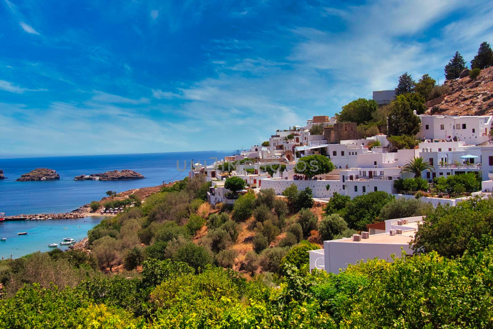 Lindos city with blue sky and some clouds over the sea. High quality photo. Lpvely Skyline of an old city