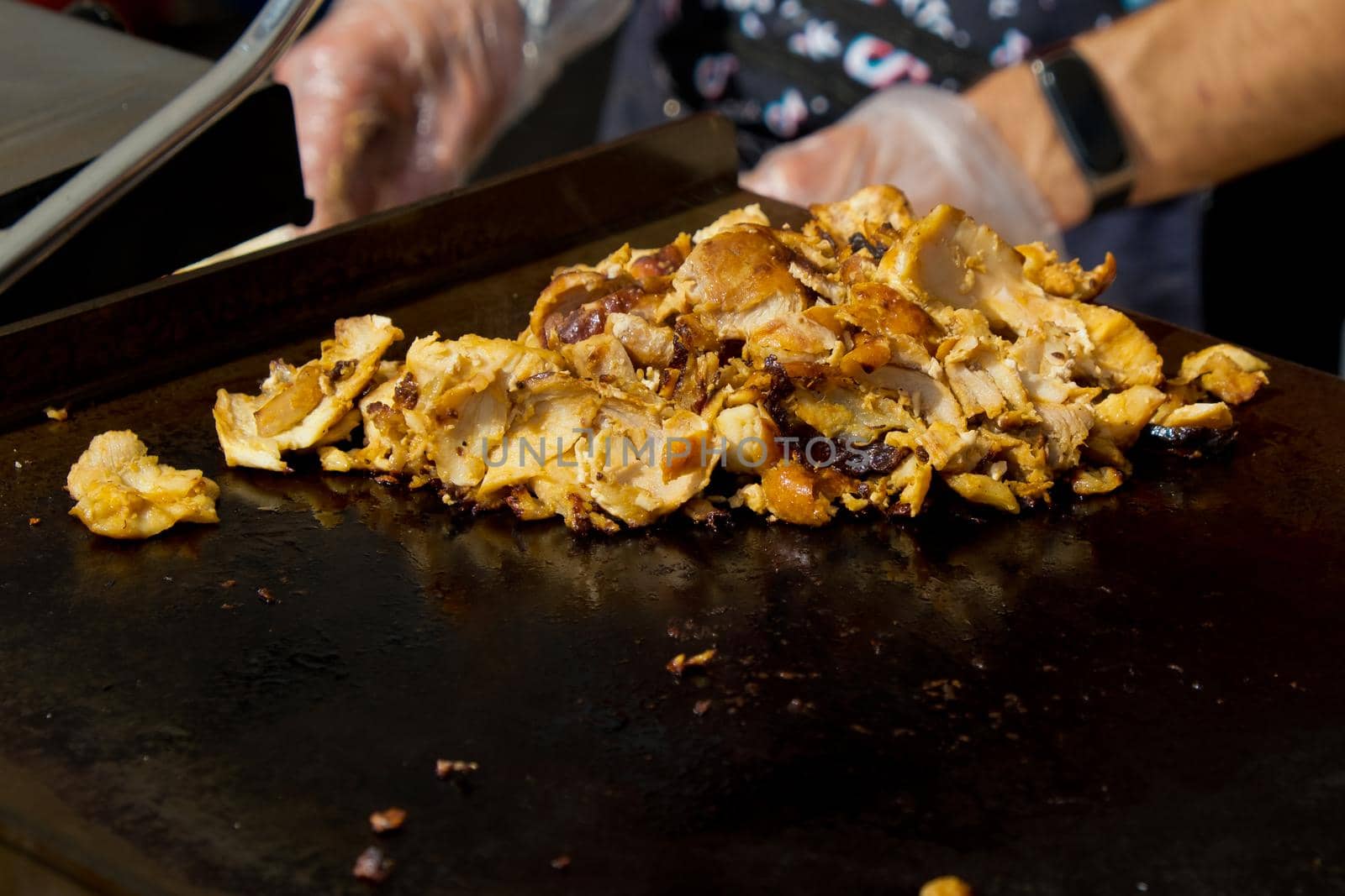 Chunks of fried chicken for making shawarma. Street food festival. Selective focus.
