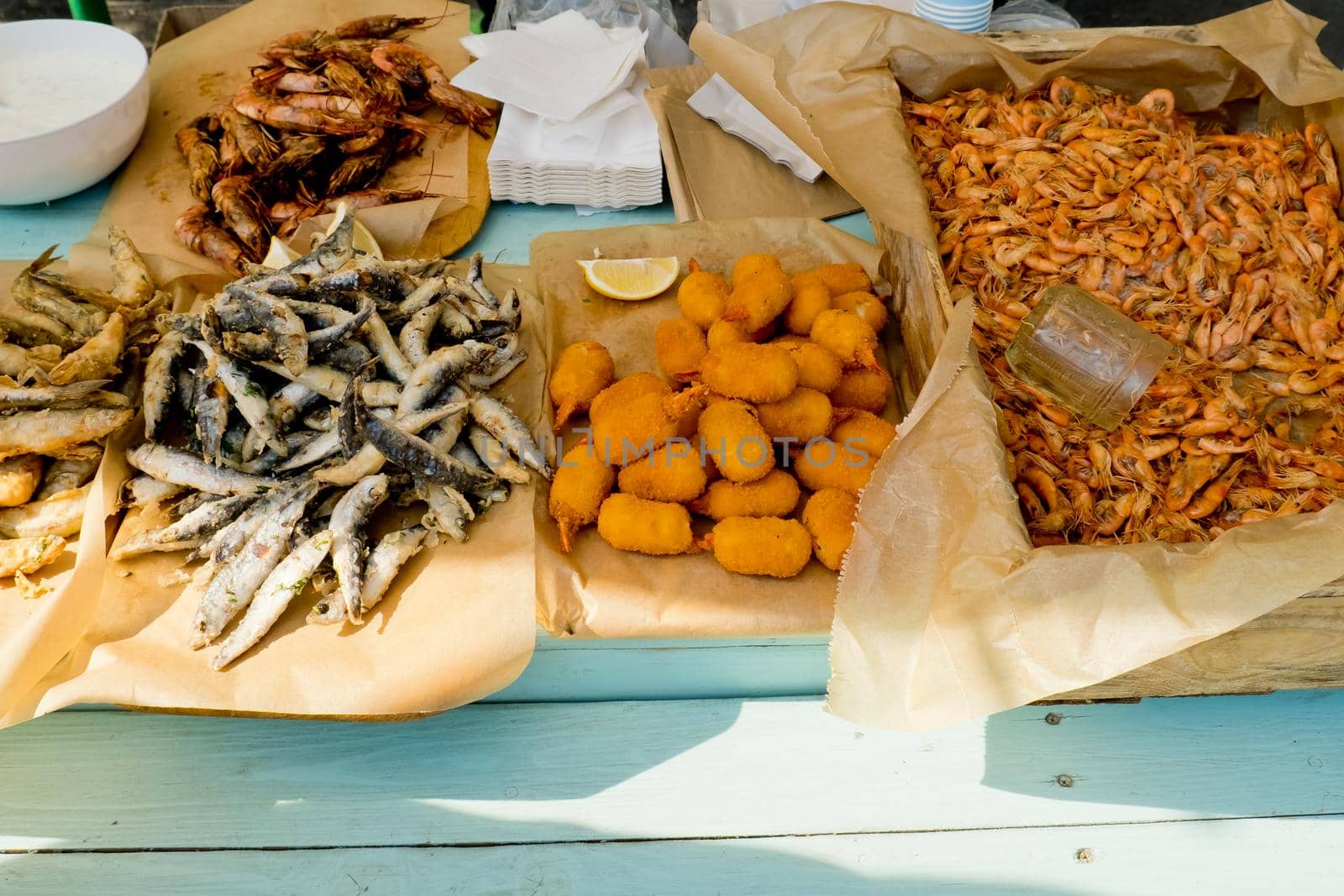 Various fried seafood on the counter ready to eat. Street food festival. Selective focus. by leonik